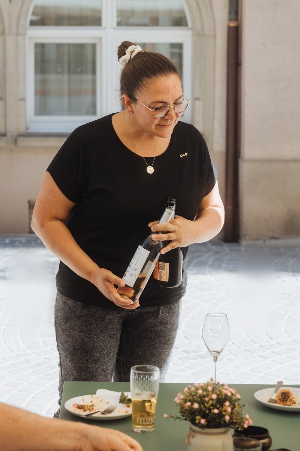 Sheri Serviert Wein auf der Terrasse